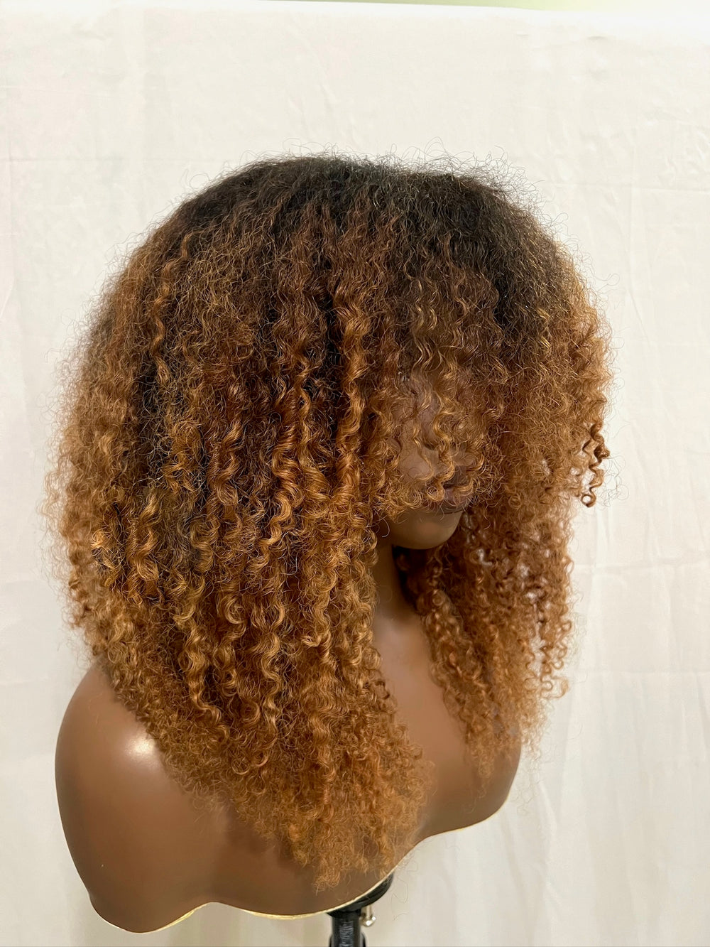 hand bleached color, curtain bangs and is crafted from 100% human kinky hair